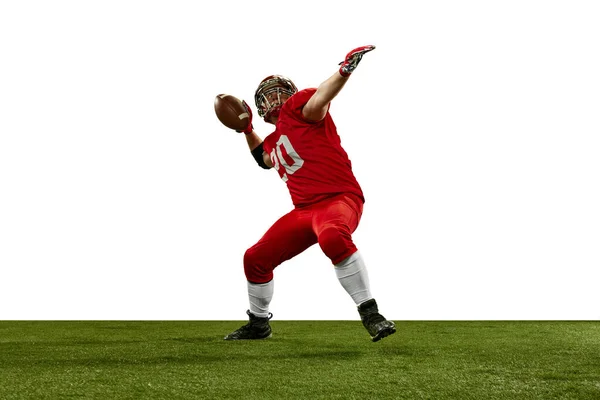 赤の制服とヘルメットの男 ゲーム中に運動中のアメリカのサッカー選手 白い背景にボールを提供しています プロスポーツ アクション ライフスタイル トレーニング 広告の概念 — ストック写真