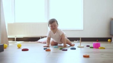 Şirin, akıllı küçük kız, evde yerde oturan, oyuncaklarla oynayan, gülümseyen ve emeklemeye başlayan bebek. Çocukluk kavramı, duygular, bakım, sağlık, yaşam, doğum, annelik, reklam