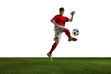 Genç atletik adam, futbol, üniformalı futbolcu, bacağı beyaz arka planda tekmeleyen top. Profesyonel spor, eylem, yaşam tarzı, rekabet, hobi, eğitim, reklam kavramı