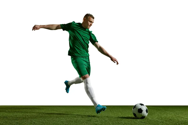 身穿绿色制服的年轻人 足球在运动 在白种人的背景下在运动场上踢球 职业体育 生活方式 业余爱好 广告等概念 — 图库照片
