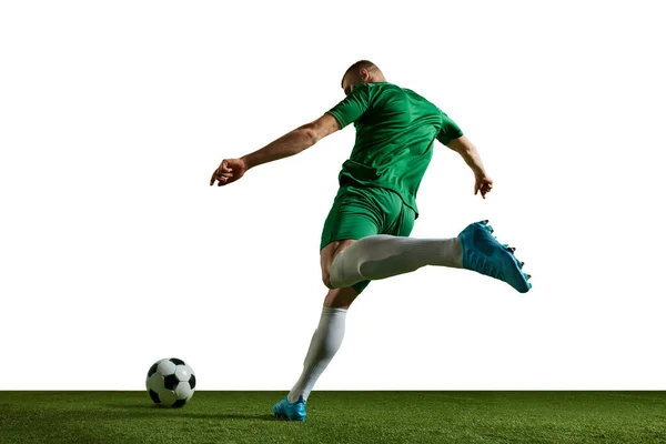 若い男は 運動中の緑の制服を着たサッカー選手 ボールを蹴り トレーニング 白い背景に対してプレー プロスポーツ アクション ライフスタイル トレーニング 広告の概念 — ストック写真