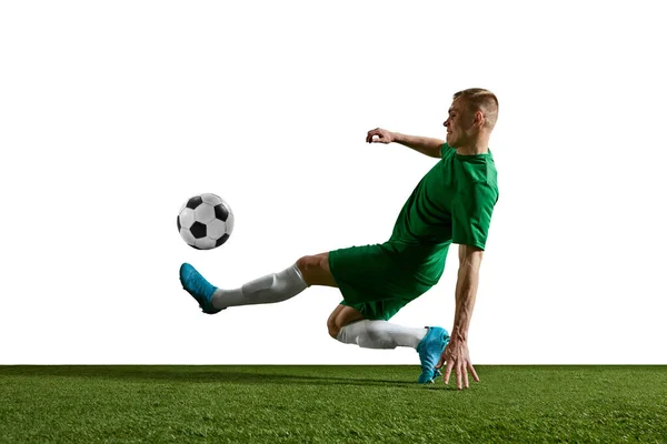 若いやる気のある男 運動中の緑の制服を着たサッカー選手 トレーニング 白い背景に対して再生 プロスポーツ アクション ライフスタイル トレーニング 広告の概念 — ストック写真
