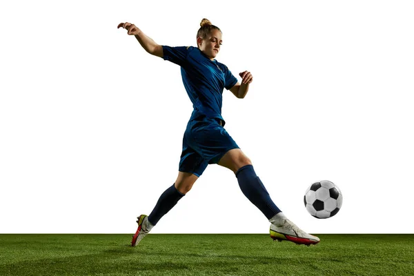 白い背景を背景に スポーツフィールド上のボールと運動中の女性アスリート 若い女の子 サッカー選手のダイナミックなイメージ プロスポーツ アクション ライフスタイル トレーニング 広告の概念 — ストック写真