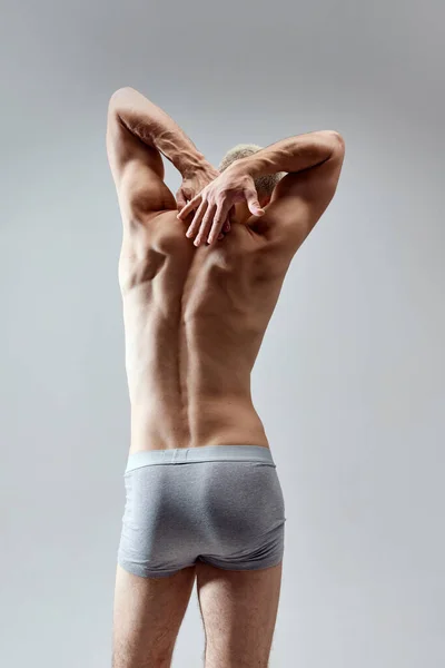 后视镜图像无上衣 肌肉发达 背向灰色工作室背景 穿着内裤的年轻模特男性自然美 身体护理 广告等概念 — 图库照片