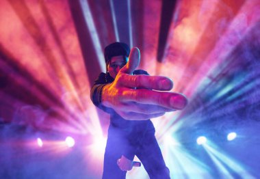 Rap sanatçısı. Genç, yetenekli, sanatsal bir adam gece kulübünde performans sergiliyor, renkli neon fenerlerin üzerinde şarkı söylüyor. Müzik, performans, sanat, yetenek, gece hayatı, neşe, parti, yaşam tarzı kavramı