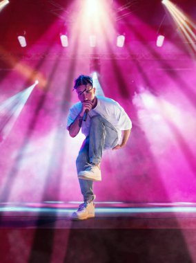 Genç sanatçı, müzisyen canlı konser veriyor, şarkı söylüyor, renkli neon ışıklar altında sahnede dans ediyor. Gece kulübü. Müzik, performans, sanat, yetenek, gece hayatı, eğlence, parti ve yaşam tarzı konsepti