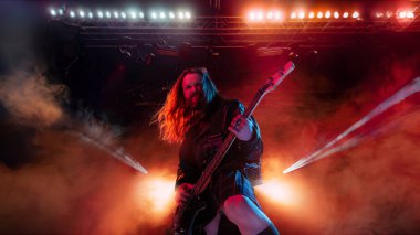 Rock 'n Roll konseri. Sanatçı, uzun saçlı, gitar çalan ve performans gösteren duygusal olarak şarkı söyleyen biri. Müzik, performans, sanat, yetenek, gece hayatı, neşe, parti, yaşam tarzı kavramı