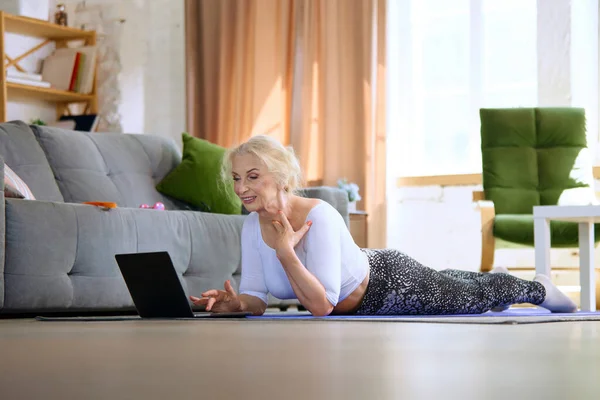 Schöne Seniorin Auf Fitnessmatte Liegend Auf Laptop Schauend Auf Der — Stockfoto