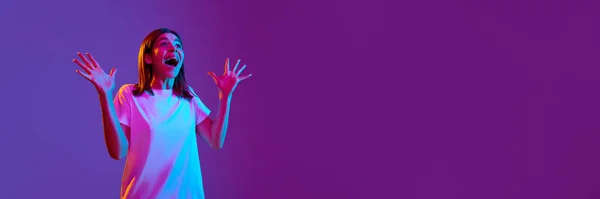 ネオンライトのグラデーション紫色の背景に驚きの手を広げカジュアルな服を着た超興奮し 幸せな若い女の子 人間の感情 ファッション ライフスタイル 広告の概念 バナー — ストック写真