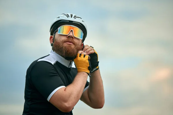 Joven Barbudo Ciclista Gafas Deportivas Degradadas Poniéndose Casco Sobre Fondo — Foto de Stock