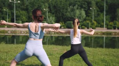 Genç kız vücudunu formda tutuyor. Parkta güneşli bir sabahın erken saatlerinde dışarıda antrenman yapıyor. Esneme ve yoga. Sağlıklı ve sportif yaşam tarzı kavramı, vücut bakımı, meditasyon, aktif yaşam