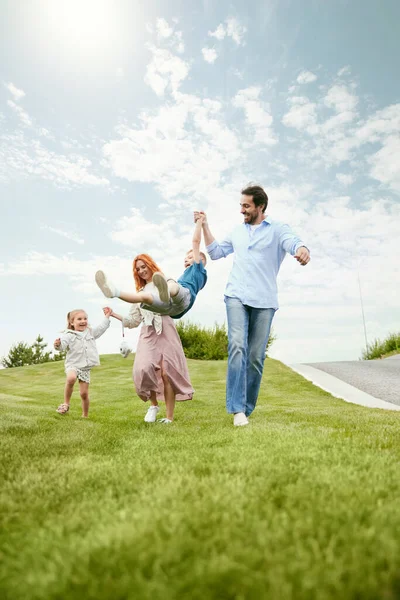 一对快乐的年轻夫妇 男人和女人 带着他们的小孩去公园散步 在温暖的夏日户外玩耍 童年和父母 广告的概念 — 图库照片