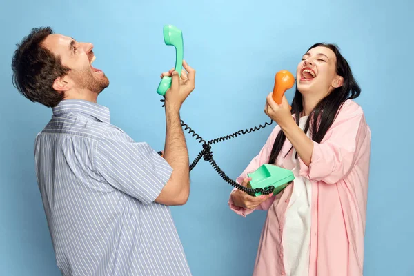 즐거운 남녀가 스튜디오 배경에 대하여 감정적으로 통화를 웃음짓고 재밌게 의사소통 — 스톡 사진