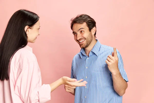 Позитивный Улыбающийся Мужчина Разговаривает Женщиной Обсуждая Новости Слухи Фоне Розовой — стоковое фото