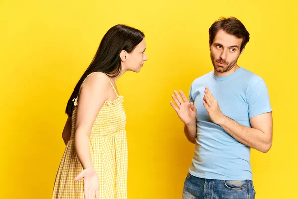 Νεαρή Γυναίκα Μιλάει Συναισθηματικά Άντρα Κάνει Ερωτήσεις Στο Κίτρινο Φόντο — Φωτογραφία Αρχείου