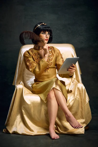 Portrait Young Thoughtful Woman Queen Cleopatra Golden Dress Sitting Tablet — Stock Photo, Image