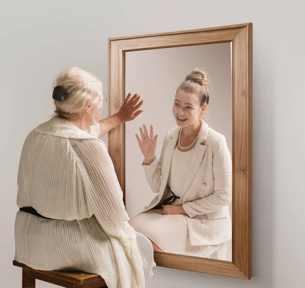 创意概念拼贴 温柔体贴的老年妇女形象 照镜子 对着她年轻的自我反思微笑 回到过去 关于现在 过去和未来 生活方式 — 图库照片