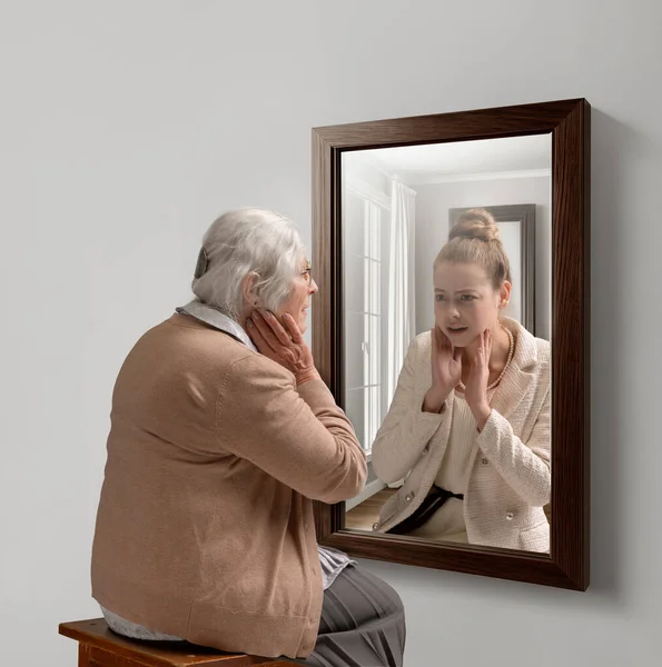 创意概念学院 年长的女人照镜子 映出她年轻的自我 老化的过程 关于现在 过去和未来 生活方式 广告的概念 — 图库照片