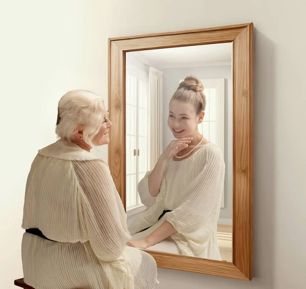 创意概念拼贴 对着镜子微笑的老年妇女 回忆着她的过去 年轻姑娘在沉思 关于现在 过去和未来 生活方式 广告的概念 — 图库照片