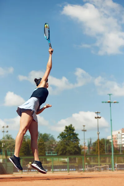 ゲーム中に運動中の集中女性テニス選手 晴れた日にオープンエアのコートでテニスをプレイ スポーツ アクティブなライフスタイル 持久力と強さの概念 — ストック写真