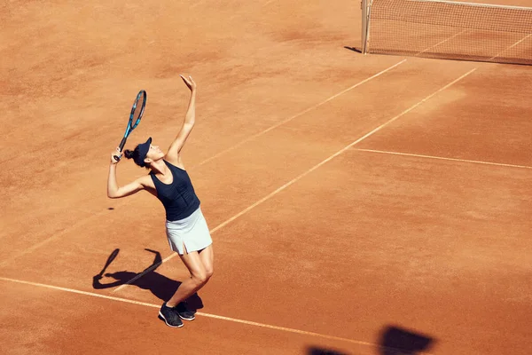 運動中のプロテニス選手のトップビュー画像 ラケット付きのボールを提供する若い女性 オープンエアのスタジアムでのトレーニング 裁判所 スポーツ アクティブなライフスタイル 広告の概念 — ストック写真