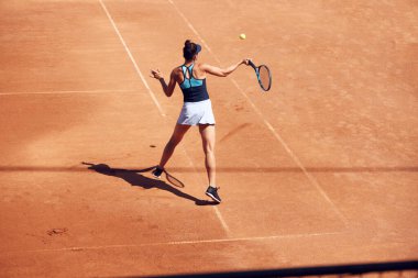 Genç bir kadının en iyi görüntüsü, tenis oyuncusu açık hava tenis kortunda maç sırasında hareket halinde. Eğitim seansı. Spor, hobi, aktif yaşam tarzı, sağlık, dayanıklılık ve güç kavramı.