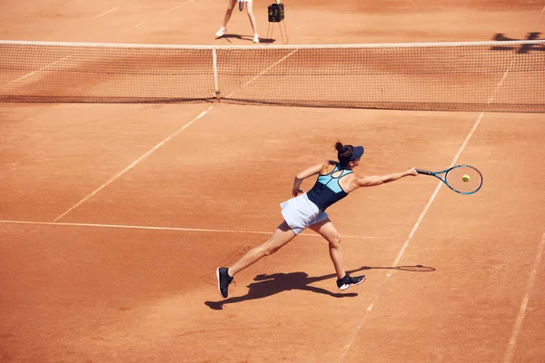 若い女性のトップビューイメージ ゲーム中に運動中のテニス選手 オープンエアのテニスコートでスイングボール 集中力だ スポーツ アクティブなライフスタイル 持久力と強さの概念 — ストック写真