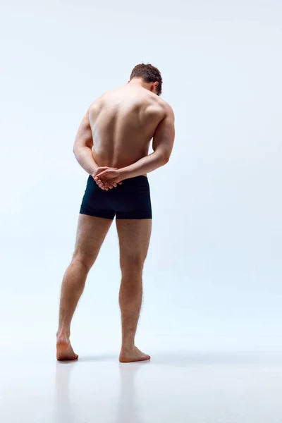 全身上下都是赤身裸体的年轻人 身强力壮 轻松自在 肌肉发达 身穿内裤 背景是灰色的工作室 男人美的概念 运动健康的生活方式 运动的身体 — 图库照片