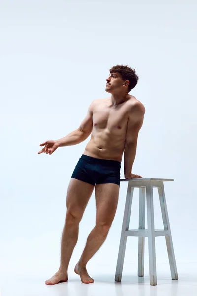 全长的年轻男子形象 肌肉发达 赤身裸体 靠在椅子上 背景为白色 男人美的概念 运动健康的生活方式 运动的身体 — 图库照片
