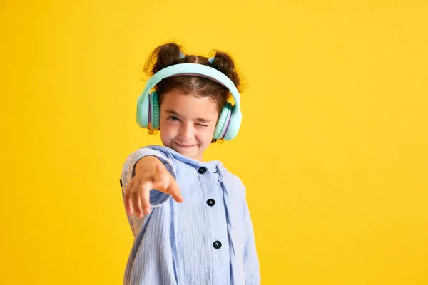 Portret Pozytywnej Dziewczynki Słuchającej Muzyki Słuchawkach Grymaszącej Żółtym Tle Studia — Zdjęcie stockowe