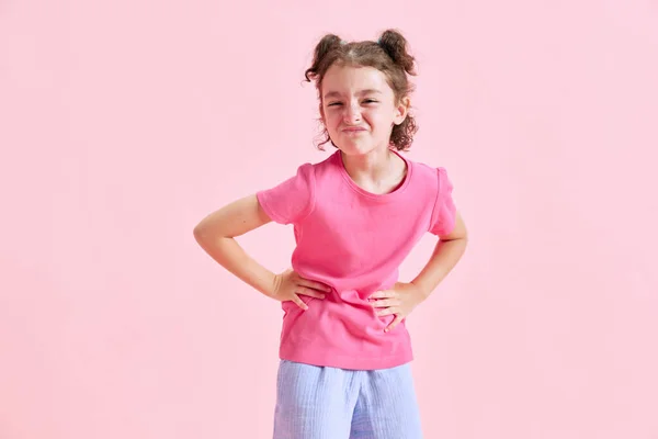一个可爱的小女孩的画像 穿着休闲装的孩子面带笑容地站在粉红的工作室背景下 情感概念 生活方式 — 图库照片