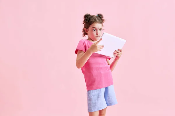 Portré Gyermek Kislány Érzelmileg Érdeklődéssel Játszik Tabletta Rózsaszín Stúdió Háttér — Stock Fotó