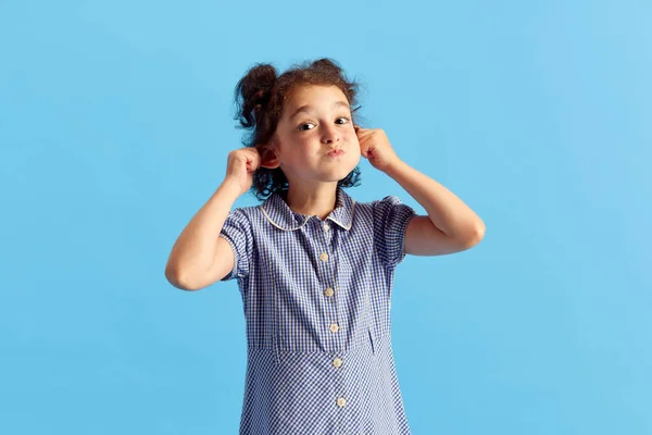 小さな女の子の肖像画 巻き毛の子供と青のスタジオの背景に対して魅力的な顔をポーズかわいい髪型 感情の概念 子供時代 ファッション ライフスタイル — ストック写真