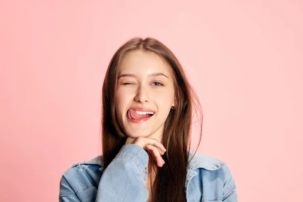 美丽的年轻女孩的画像 有着积极的情绪 在粉红的工作室背景下摆出一副鬼脸的学生形象 人类情感 生活方式 女性美 广告的概念 — 图库照片