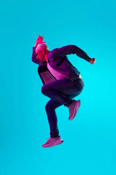 빛으로 스튜디오 배경을 점프하는 평상복을 대머리 청년의 초상화 인간의 방식에 — 스톡 사진