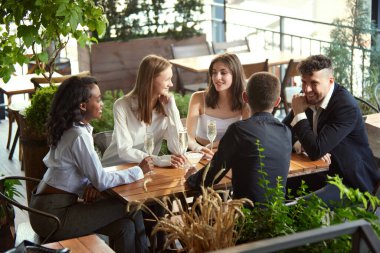 Bir grup iş adamı işten sonra restoranda buluşur, konuşur, projeleri tartışır, başarıyı kutlar ve şampanya içerler. Boş zaman kavramı, iş, takım, alkol içeceği