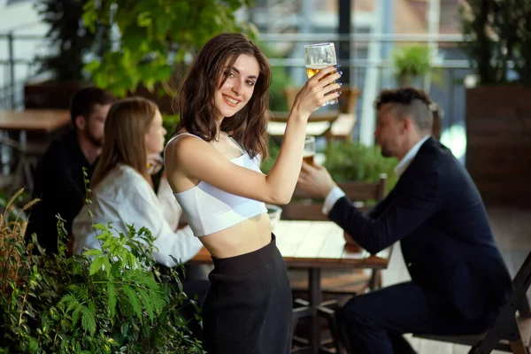 Céntrate Hermosa Chica Sonriente Levantando Vaso Cerveza Gente Borrosa Fondo — Foto de Stock