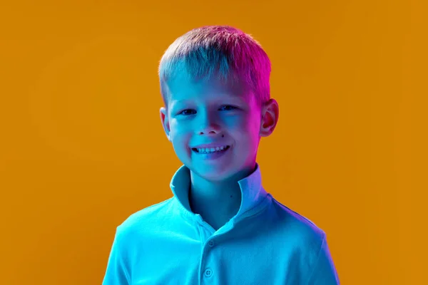 小さな男の子の肖像画 ネオンの光の中で黄色のスタジオの背景に笑顔と喜びのムードをポーズ白いシャツを着て子供 子供時代 ライフスタイル ファッション 広告コンセプト — ストック写真