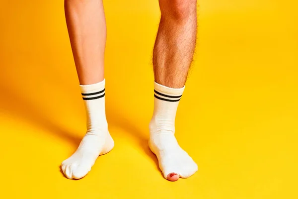 Мужские Женские Ноги Стоят Белых Носках Ярко Желтом Фоне Студии — стоковое фото