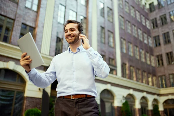 Young Businessman Standing Office Outdoors Looking Tablet Talking Mobile Phone — Stock Photo, Image