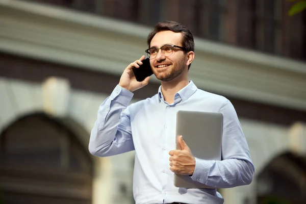 Adamı Ofisin Dışında Yürüyor Dizüstü Bilgisayarını Tutuyor Cep Telefonuyla Konuşuyor — Stok fotoğraf