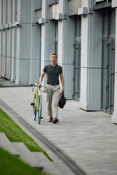 全长形象严肃 年轻英俊的商人穿着聪明的休闲装 骑着自行车在街上走着 商业概念 积极的生活方式 — 图库照片