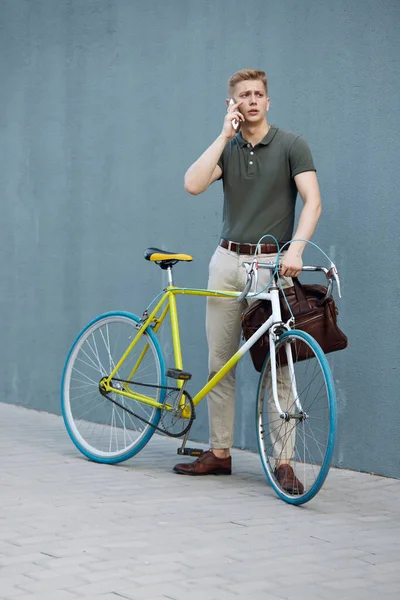 自転車で屋外に立ち 携帯電話で話すスマートカジュアル服でハンサムな 集中し スタイリッシュなビジネスマン ビジネス アクティブライフスタイル ファッション 生態学の概念 — ストック写真