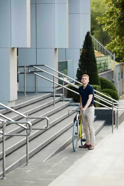自転車でオフィスビルの近くに立ってスマートカジュアル服のハンサムな スタイリッシュな従業員 労働者 自転車で仕事に行く ビジネス アクティブライフスタイル ファッション 生態学の概念 — ストック写真