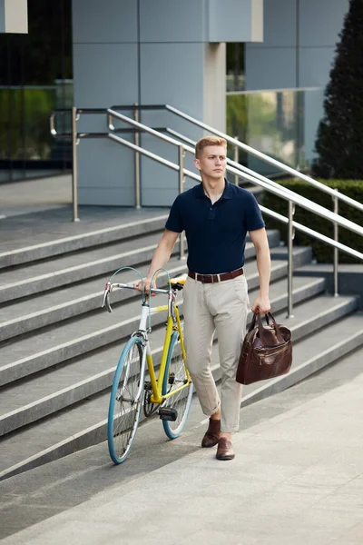 自転車でオフィスビルの近くに立ってスマートカジュアル服のハンサムな スタイリッシュな従業員 労働者 自転車で仕事に行く ビジネス アクティブライフスタイル ファッション 生態学の概念 — ストック写真