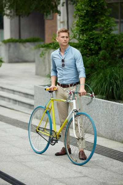 若いハンサムなビジネスマン 自転車で屋外に立ってスタイリッシュなスマートカジュアル服のオフィスワーカー 美しい都市の背景 ビジネス アクティブライフスタイル ファッション 生態学の概念 — ストック写真