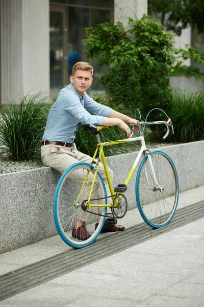 ビジネスマン オフィスワーカーは自転車でオフィスの外の通りに座って スタイリッシュなスマートカジュアル服を着ています 都市の背景 ビジネス アクティブライフスタイル ファッション 生態学の概念 — ストック写真