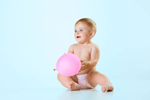 美しい小さな赤ちゃんの肖像画 おむつにおむつを床に座らせ 明るい青色の背景に対して気球で遊ぶ 子供時代 ライフスタイル ケアの概念 Adのためのスペースをコピーする — ストック写真