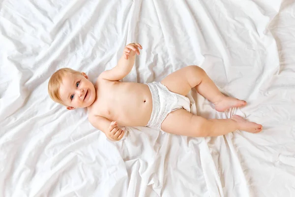 美しく かわいい小さな赤ちゃん ベッドの上に横たわっているおむつにトッドラー 見て笑顔 子供の世話をする 子供の頃の概念 新生児のライフスタイル Adのためのスペースをコピーする — ストック写真