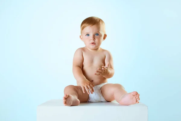 小さな美しい赤ちゃんの肖像画 おむつの中の幼児は静かに座って ライトブルーのスタジオの背景を見ています 子供の頃の概念 新生児のライフスタイル Adのためのスペースをコピーする — ストック写真